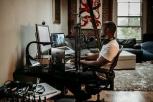 Man In White T-Shirt Sitting On Black Office Rolling Chair