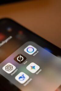 Smartphone screen displays ai app icons: chatgpt, grok, meta ai, gemini.